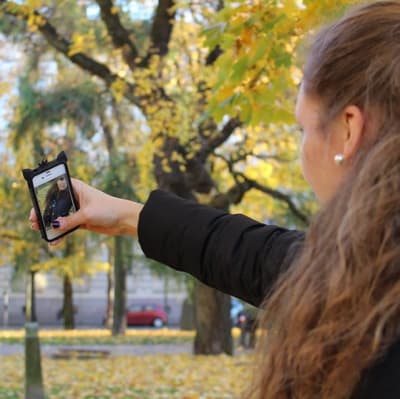 En flicka tar en selfie med sin telefon.