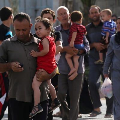 Palestiinalaiset pakenivat kodeistaan Gazassa Israelin iskujen seurauksena 13. heinäkuuta 2014.