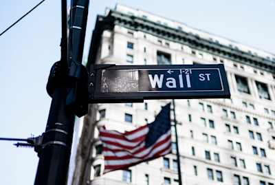 Wall Street, gatuskylt. Den amerikanska flaggan i bakgrunden. 