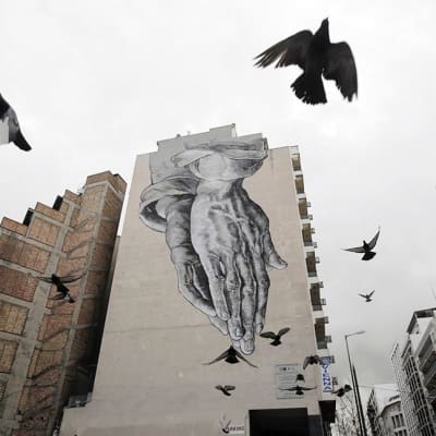 RAkennuksen seinään maalattu graffiti ja puluja Ateenan keskustassa 24. helmikuuta.