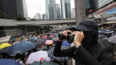 En demonstrant med kikare i Hongkong
