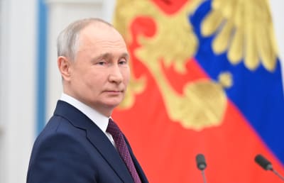 Vladimir Putin puolilähikuvassa. Taustalla Venäjän lippu.