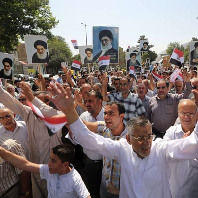 Iranissa asuvaa irakilaisväestöä sunnivastaisessa mielenosoituksessa Tehranissa 20. kesäkuuta 2014. Shiiaenemmistöinen Iran on jo aikaisemmin ilmoittanut auttavansa Irakia taistelussa ISIS-kapinallisia vastaan, mikäli se on tarpeellista. 