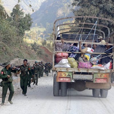 sotilaita ja kuorma-auto täynnä pakolaisia