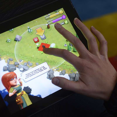Pelaaja pelaamassa Supercellin suunnittelemaa Clash of Clans -peliä iPadillä.
