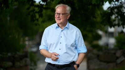 Olli Rehn tittar åt sidan och ler.