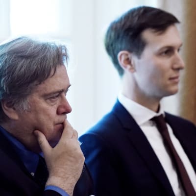 Bannon istuu etualalla pitäen kättään leuallaan. Taustalla istuu Jared Kushner.