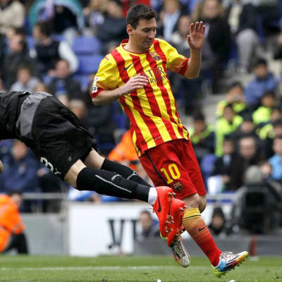Espanyolin maalivahti Kiko Casilla koppaa pallon Barcelonan Lionel Messin edestä.