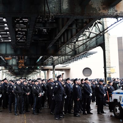Sadat poliisivirkailijat käänsivät selkänsä New Yorkin kaupungin pormestarille hänen pitäessään puhetta hautajaisissa 4. tammikuuta.