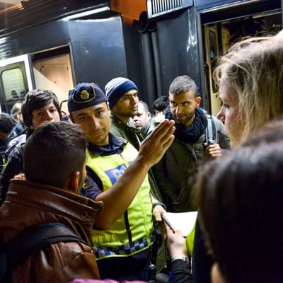 Poliisi opasti siirtolaisia Tukholman juna-asemalla 12. syyskuuta.