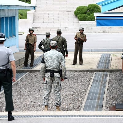Nordkoreanska soldater (i bakgrunden) ser på sydkoreanska soldater i gränsbyn Panmunjom i juli år 2015.
