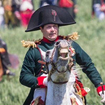 Ranskalainen näyttelijä Frank Simson hirnuvan hevosen selässä eli Napoleonina Waterloon taisteluesityksessä Lignyssa Belgiassa kesäkuussa 2015