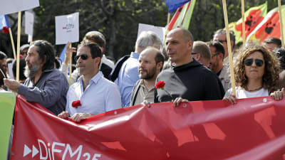 Greklands tidigare finansminister Yanis Varoufakis håller en Diem 25-banderoll under en demonstration i Portugal.