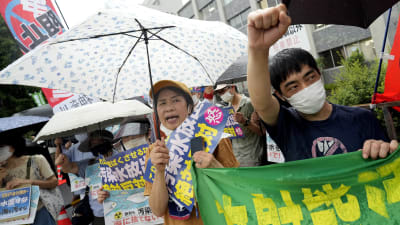 Människor demonstrerar mot att Fukushimas vatten släpps ut.