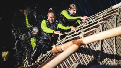 Ungdomar i serien Tuffast i Norge klättrar upp från havet längs en repstege.