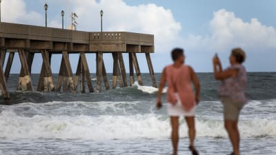 Folk fortograferar de stora vågorna vid en strand i North Carolina.