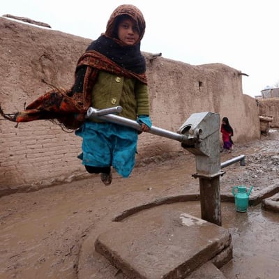 Afganistanilainen tyttö täyttää vesikanisteria.