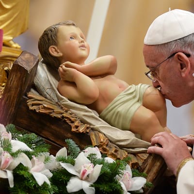 Paavi Franciscus suuteli Jeesus-lasta esittävää patsasta jouluyön messussa Pietarinkirkossa Vatikaanissa 24. joulukuuta.