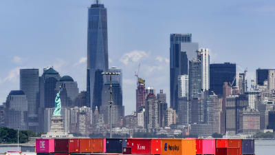 Färggranna containrar i hamnen i New York. I bakgrunden syns Frihetsstatyn