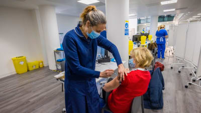 En kvinna vaccineras mot covid-19 i England.