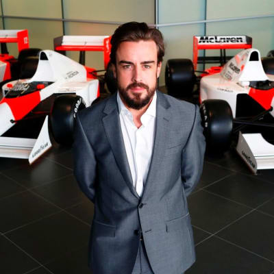 McLarenin Fernando Alonso poseeraa tallin autojen edessä.