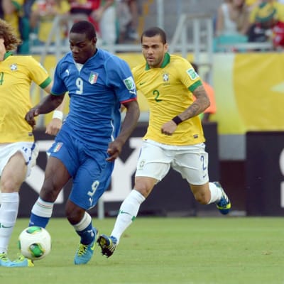 Brasilian David Luiz ja Dani Alves yrittävät pysäyttää Italian Mario Balotellin.