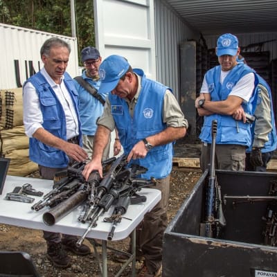 YK:n työntekijät vastaanottavat Farc-kapinallisten aseita Kolumbiassa.
