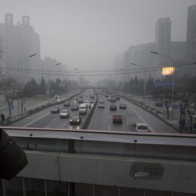 Kasvosuojusta käyttänyt mies kävele Pekingin toisen kehätien ylittävällä sillalla.