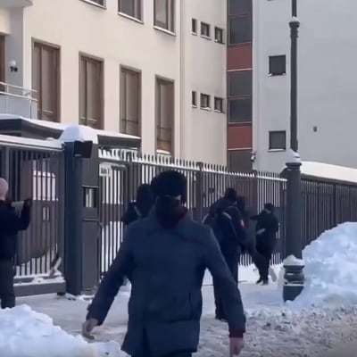 Maskerade människor med släggor utanför Finlands ambassad i Moskva i vinterväder.