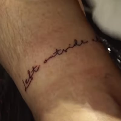 Närbild av en tatuering där det står "Left outside alone".