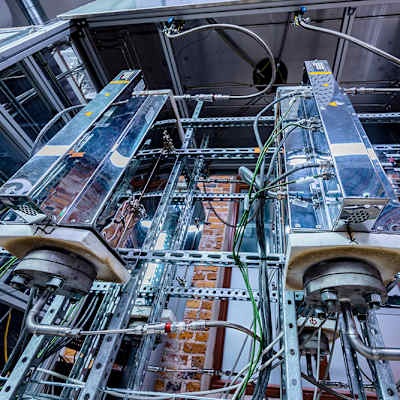 Putkistoja ja säiliöitä kiinnitettynä metallitelineisiin vasten tiiliseinää. 