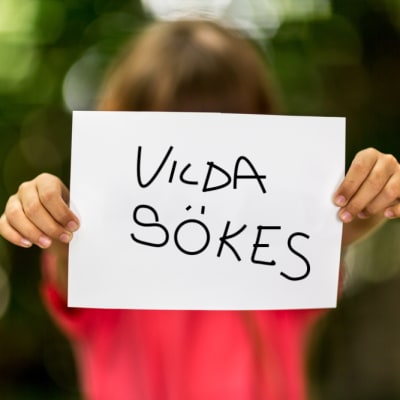 Flicka håller upp papper med texten "Vilda sökes"