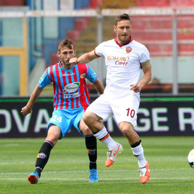 Francesco Totti ottaa pallon haltuun Catanian Norbert Gyomberin edestä.
