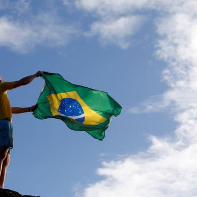 Mies heiluttaa Brasilian lippua.