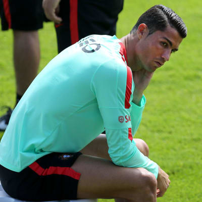 Cristiano Ronaldo istuskelee harjoituskentällä.