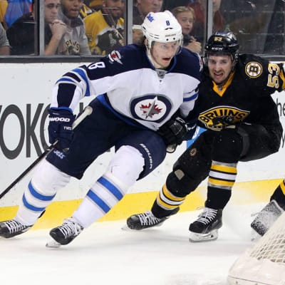 Winnipeg Jetsin Jacob Trouba ja Boston Bruinsin Seth Griffith kamppailevat kiekosta.
