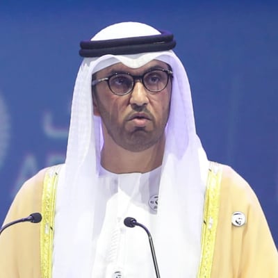 Sultanen Ahmed Al Jaber iklädd en vit kandura står och talar på ett evenemang.