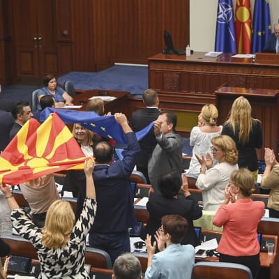 Kompromissiehdotusta kannattaneet kansanedustajat heiluttivat Pohjois-Makedonian ja EU:n lippuja parlamentissa. 