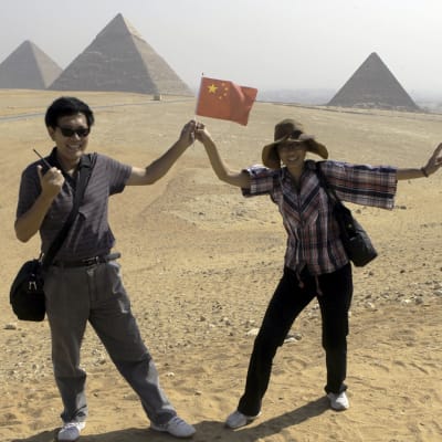 Kinesiska turister poserar framför Gizapyramiderna i Egypten 1.10.2012.