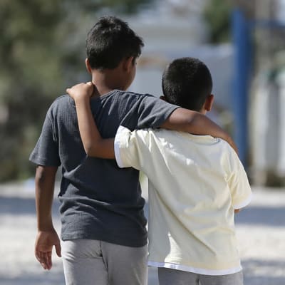 Två barn som har armarna runt varandra. Barnen är på flyktinglägret Kara Tepe på ön Lesbos i Grekland. Bilden är från år 2017.