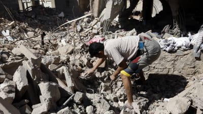 Räddningsarbetare letar efter överlevande i ruinerna av ett bostadshus som förstördes i en saudiarabisk attack mot Jemens huvudstad Sanaa.