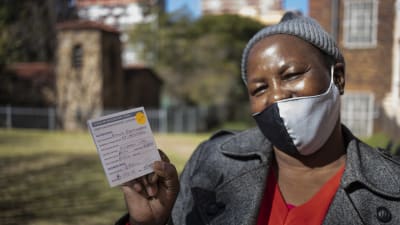En kvinna i Johannesburg i Sydafrika visar upp sitt intyg på att hon har fått två doser coronavaccin.