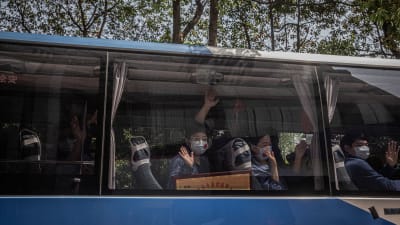 Sjukvårdare från provisnen Shandong vinkar från en buss då de åker hem från Wuhan 6.4.2020