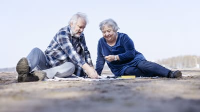 en man och en kvinna sitter på picnicfilt