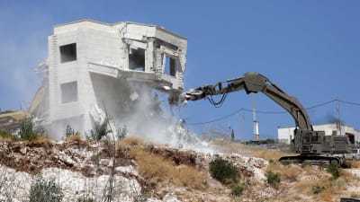 En israelisk grävmaskin river ner ett hus i en palestinsk by i östra Jerusalem i juli 2019