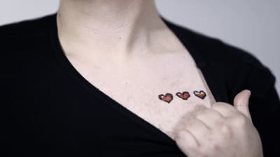 Närbild på tre hjärtan som Ludwig Sandbacka målat på sitt bröst.