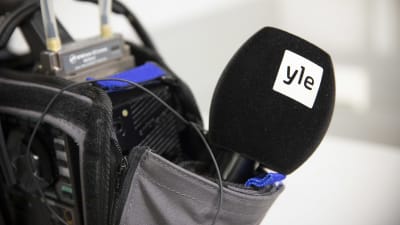 En mikrofon sticker ut ur reporterväskan.