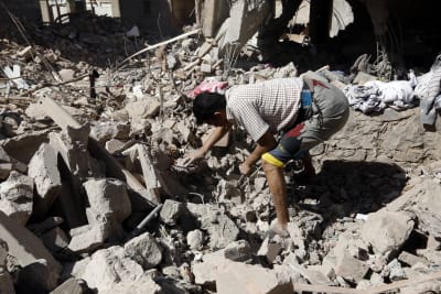 Räddningsarbetare letar efter överlevande i ruinerna av ett bostadshus som förstördes i en saudiarabisk attack mot Jemens huvudstad Sanaa.