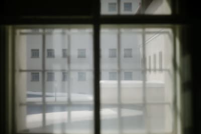 Utsikt mot fängelsens innergård från ett gallerförsett fönster.
