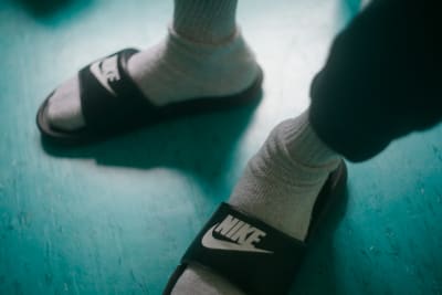En fånges fötter i Nike-sandaler i plast.